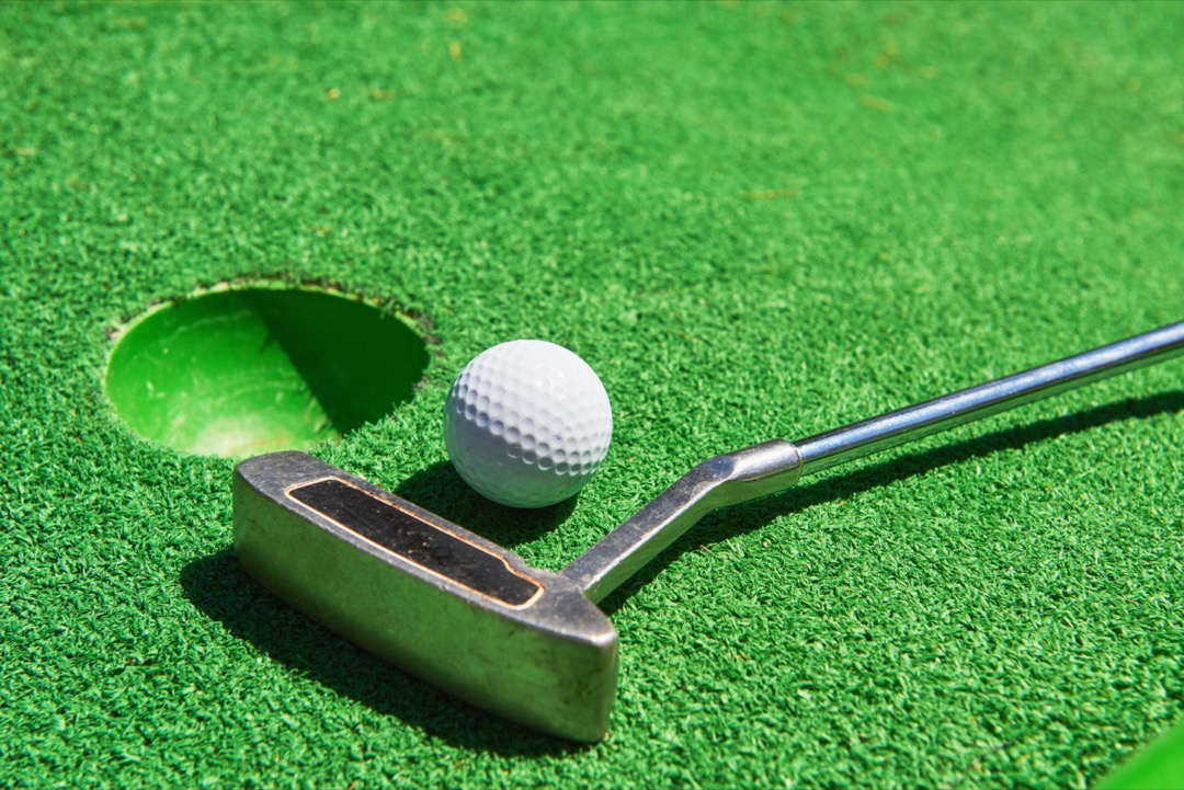 Golf ball and putter on artificial grass